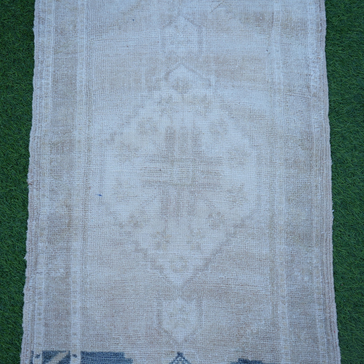Close-up of the beige Turkish authentic vintage rug showing neutral details, hand-knotted weave, wool and low pile.