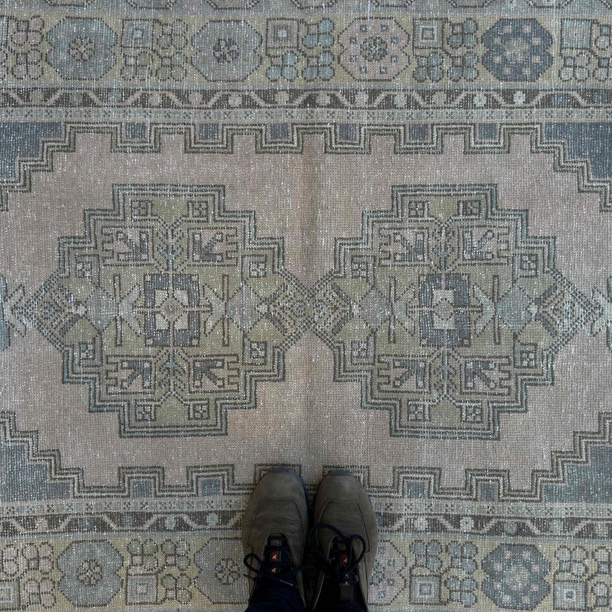 1970s beige Turkish distressed rug with traditional design, hand-knotted weave and low pile.