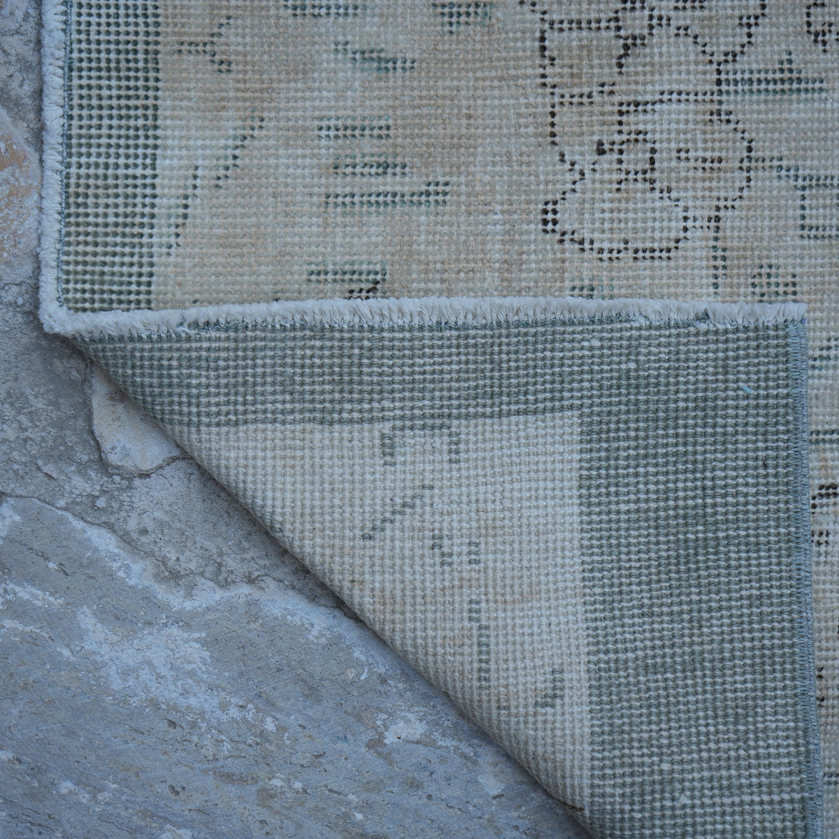 1970s beige Turkish distressed vintage rug with floral design, hand-knotted weave and low pile.