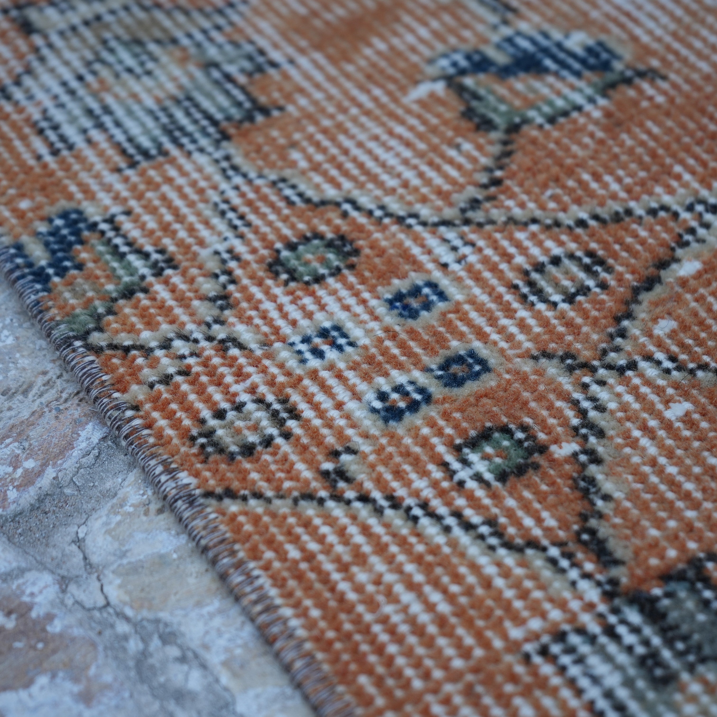 Orange 3' x 11' Turkish floral runner rug in wool and cotton, shown on the floor.