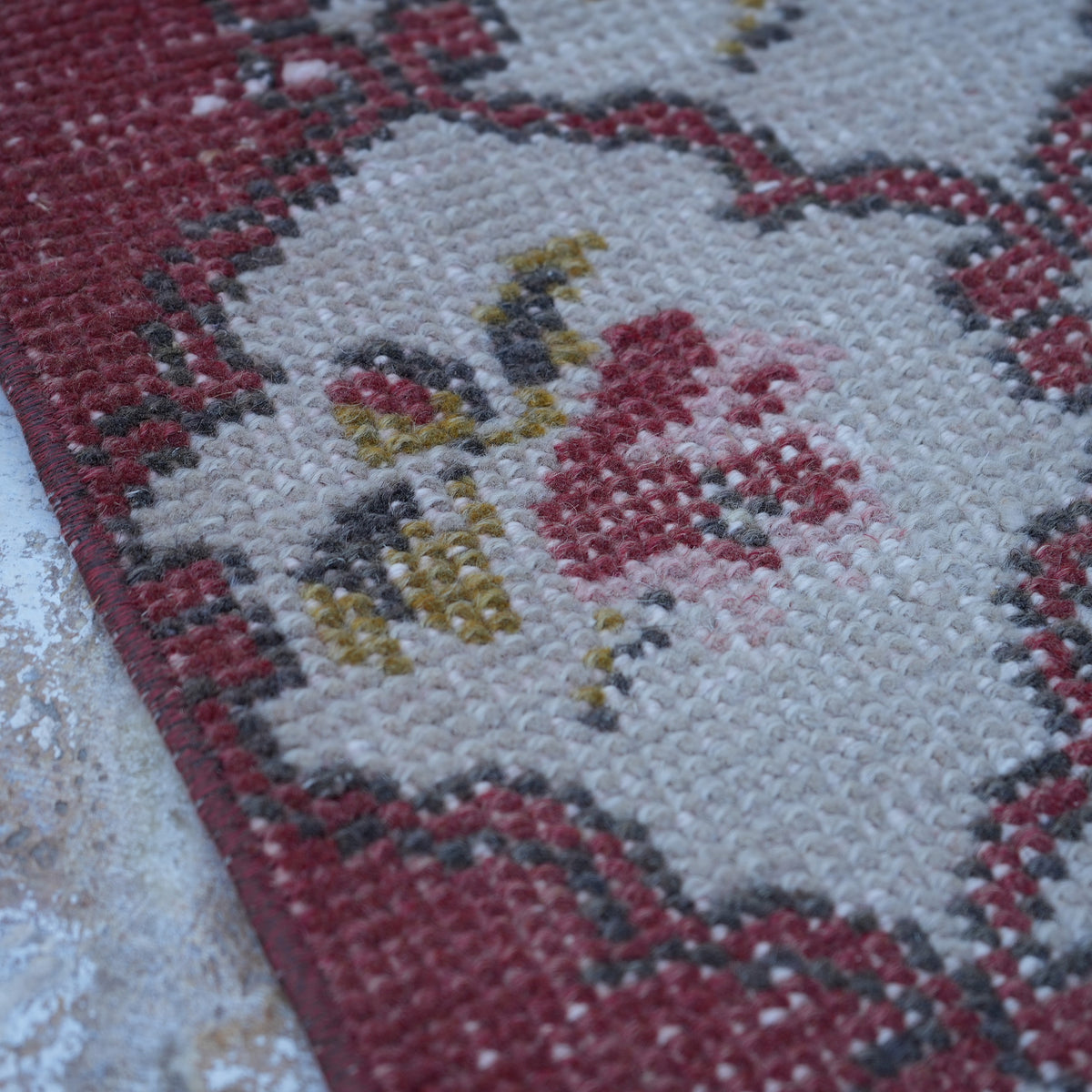 Red 4' x 7' floral turkish rug in wool and cotton, shown on the floor.