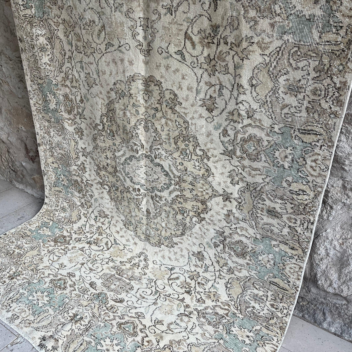 Green 5' x 9' Turkish handknotted rug in wool and cotton, shown on the floor.