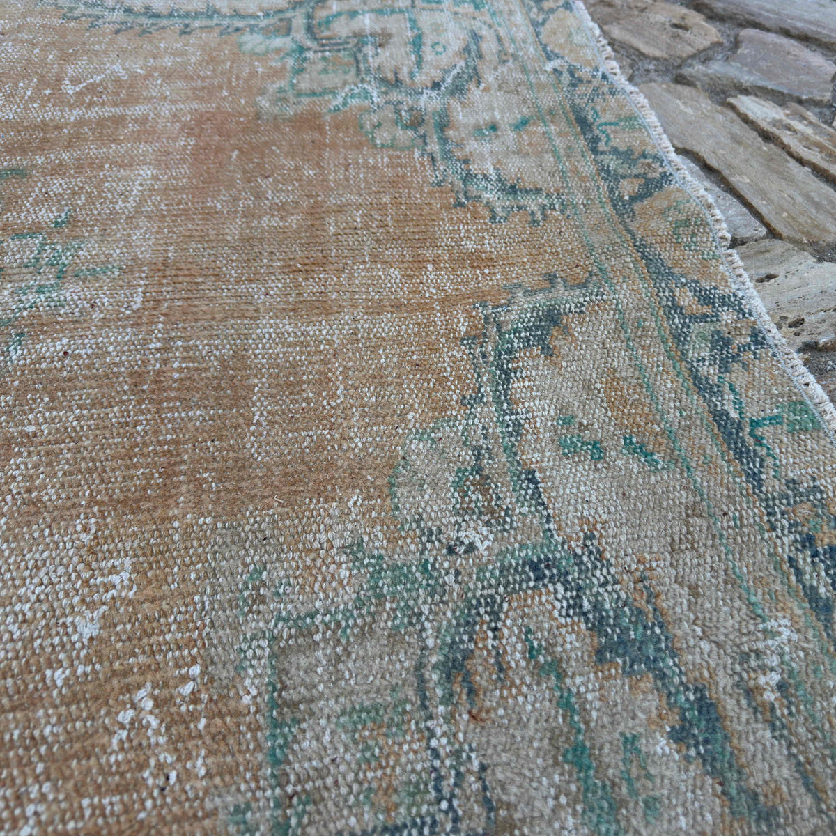 Close-up of the orange Turkish handknotted rug showing medallion details, hand-knotted weave, wool and cotton and low pile.