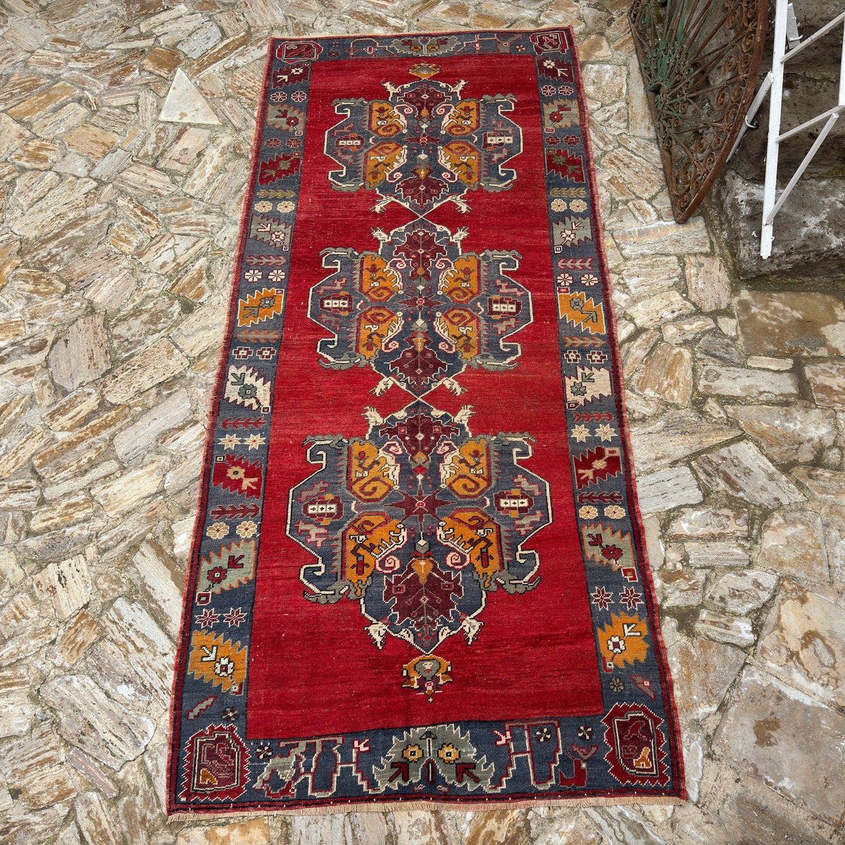 Red 5' x 12' Turkish handmade vintage carpet in wool, shown on the floor.