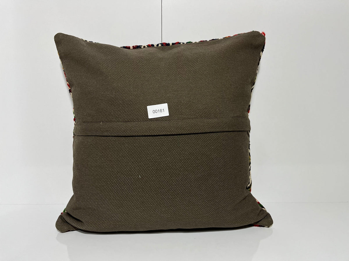 Close-up of the green Turkish kilim pillow showing geometric details.