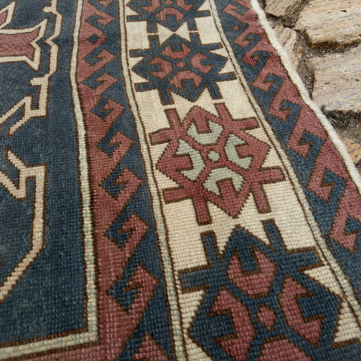 Close-up of the pale pink large turkish rug showing traditional details, hand-knotted weave, wool and cotton and low pile.