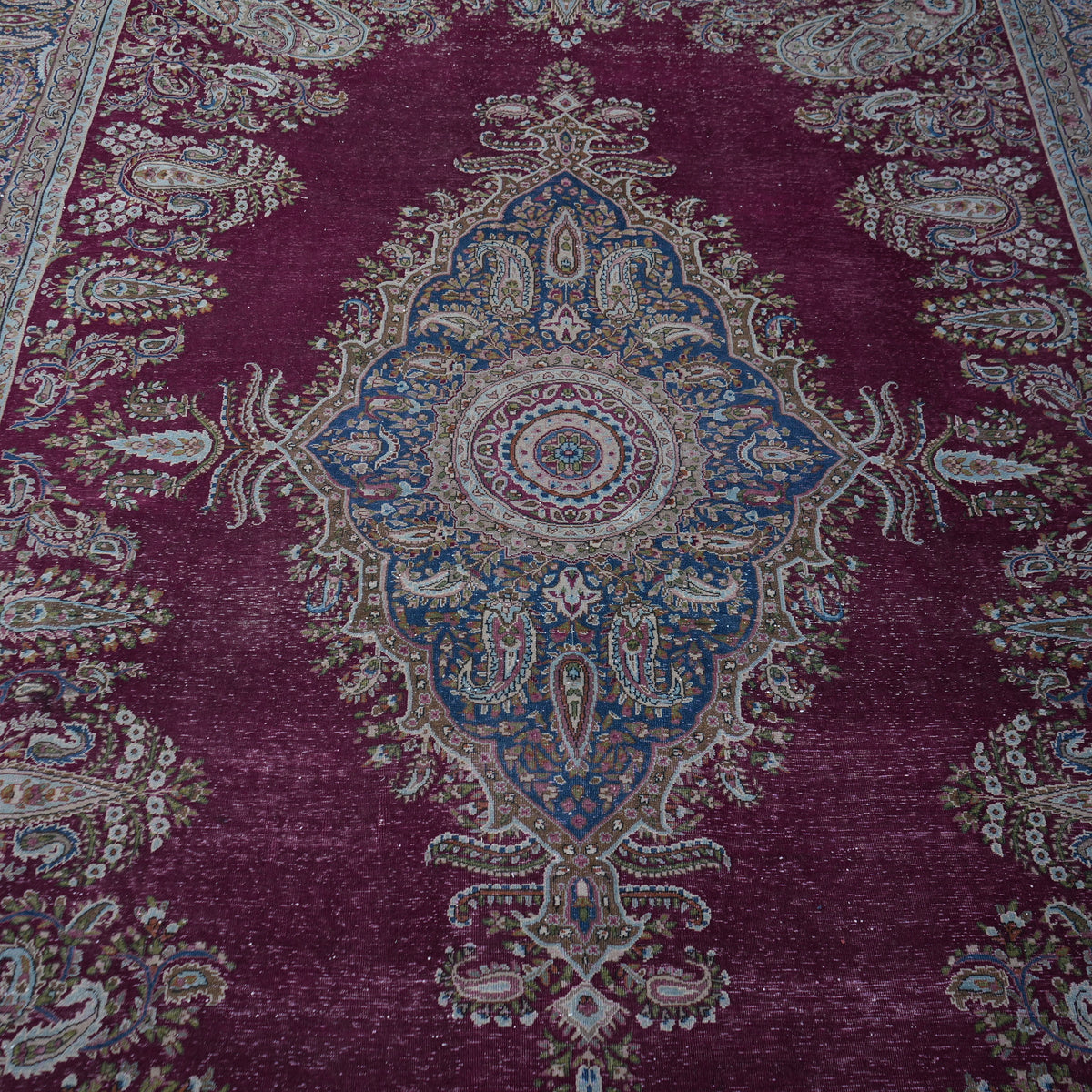 Close-up of the burgundy large vintage persian rug showing medallion details, hand-knotted weave, wool and cotton and low pile.