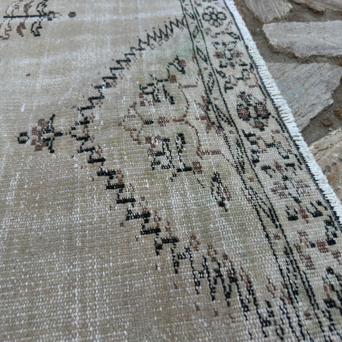 Close-up of the beige Turkish large vintage rug showing neutral details, hand-knotted weave, wool and cotton and low pile.