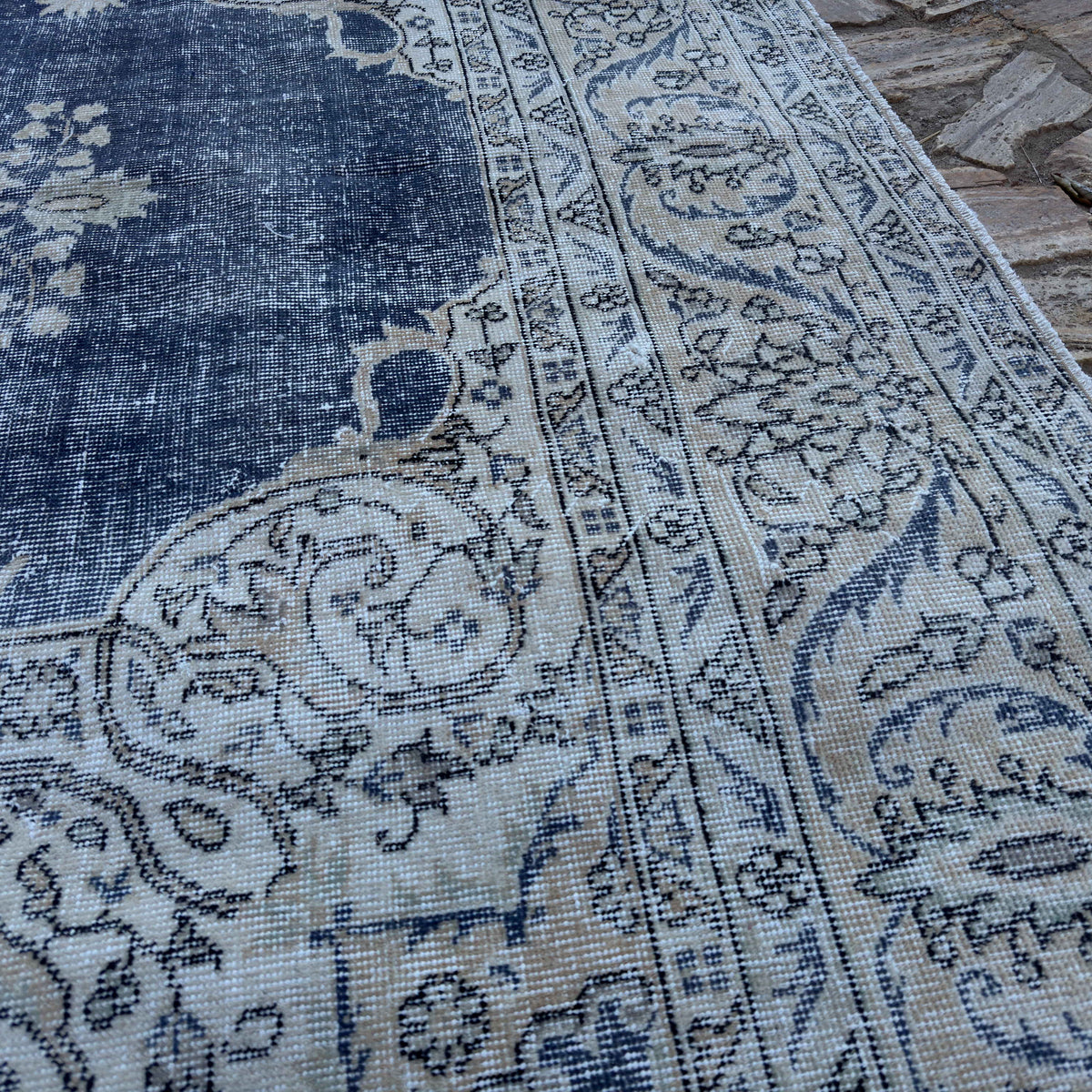 Close-up of the blue Turkish large vintage rug showing medallion and neutral details, hand-knotted weave, wool and cotton and low pile.