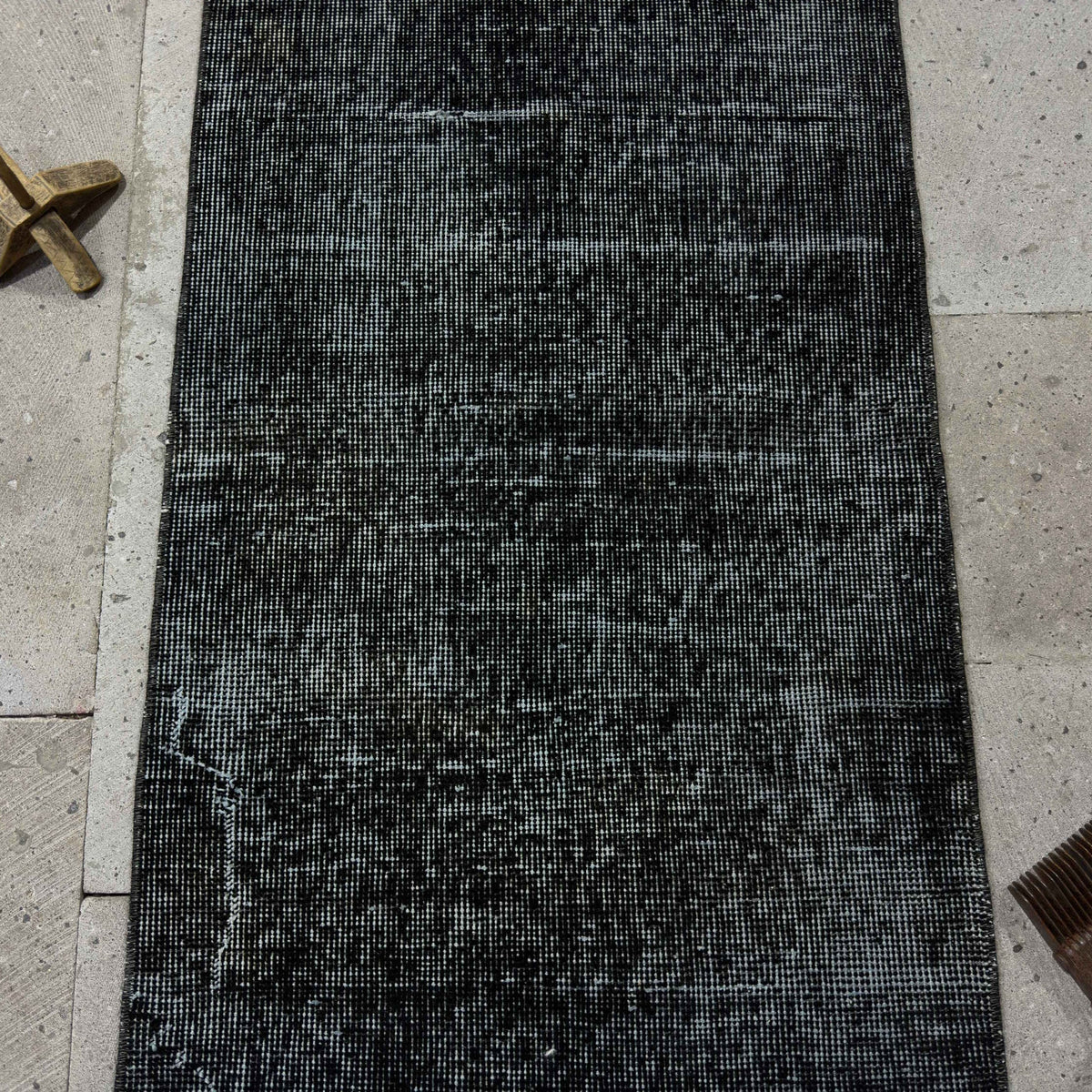 1970s black Turkish mini runner rug with overdyed design, hand-knotted weave and low pile.