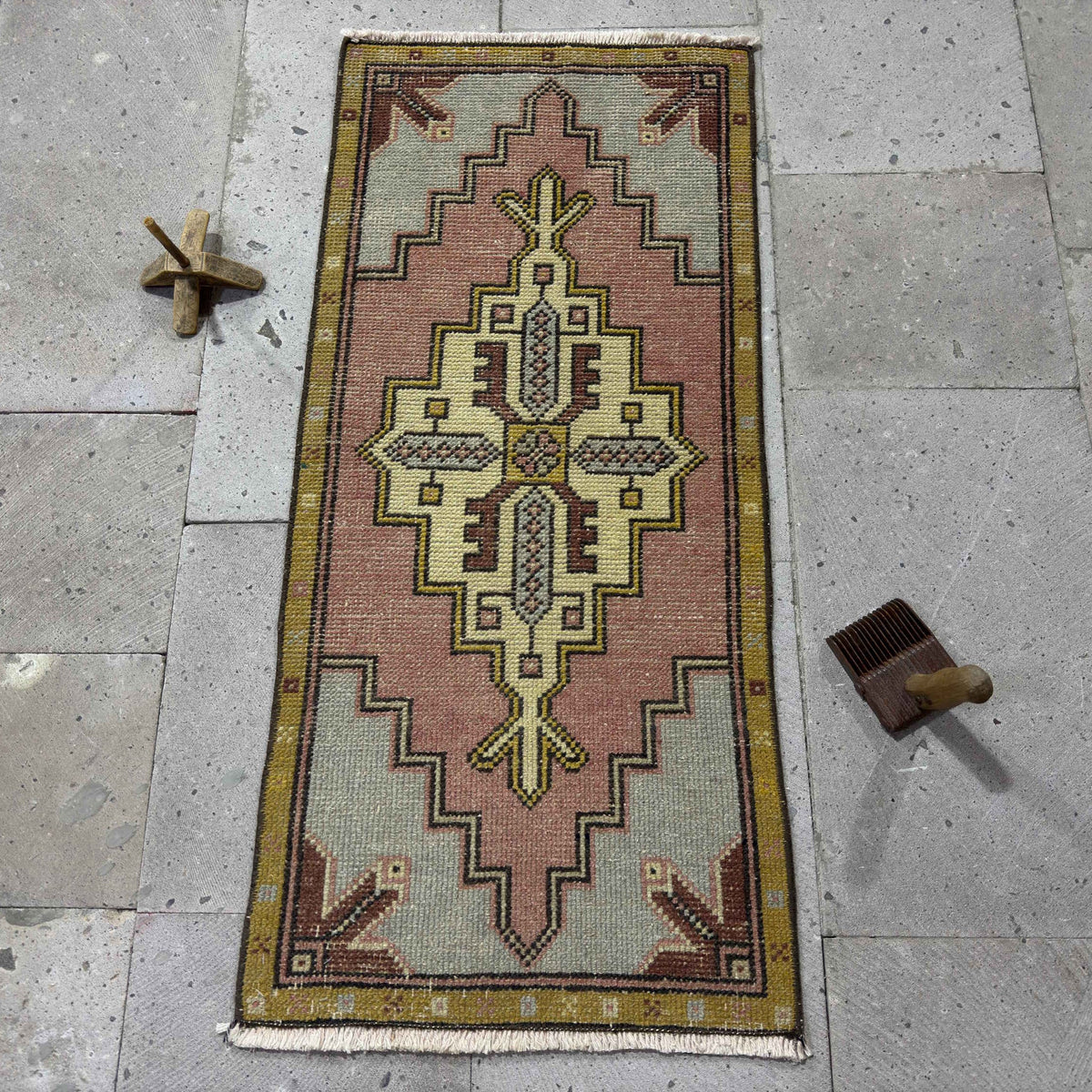 pink 2' x 3' mini turkish carpet in wool and cotton, shown on the floor.