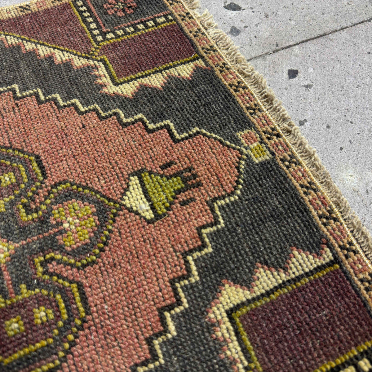 Close-up of the purple mini turkish rug showing traditional details, hand-knotted weave, wool and cotton and low pile.