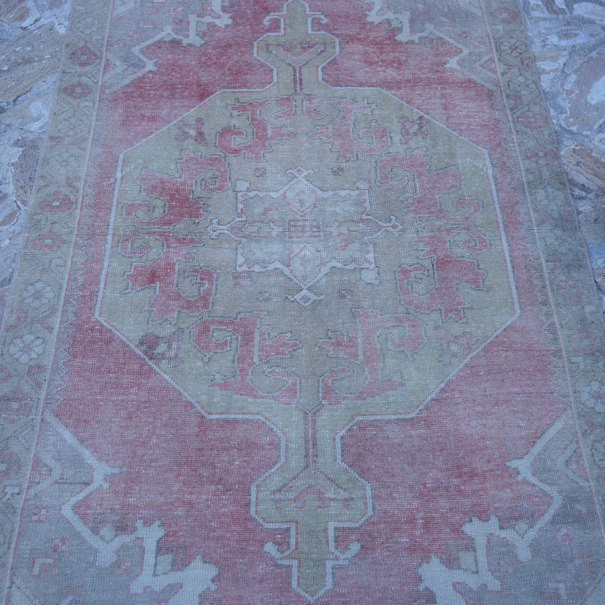 Close-up of the pale red neutral turkish rug showing neutral details, hand-knotted weave, wool and cotton and low pile.