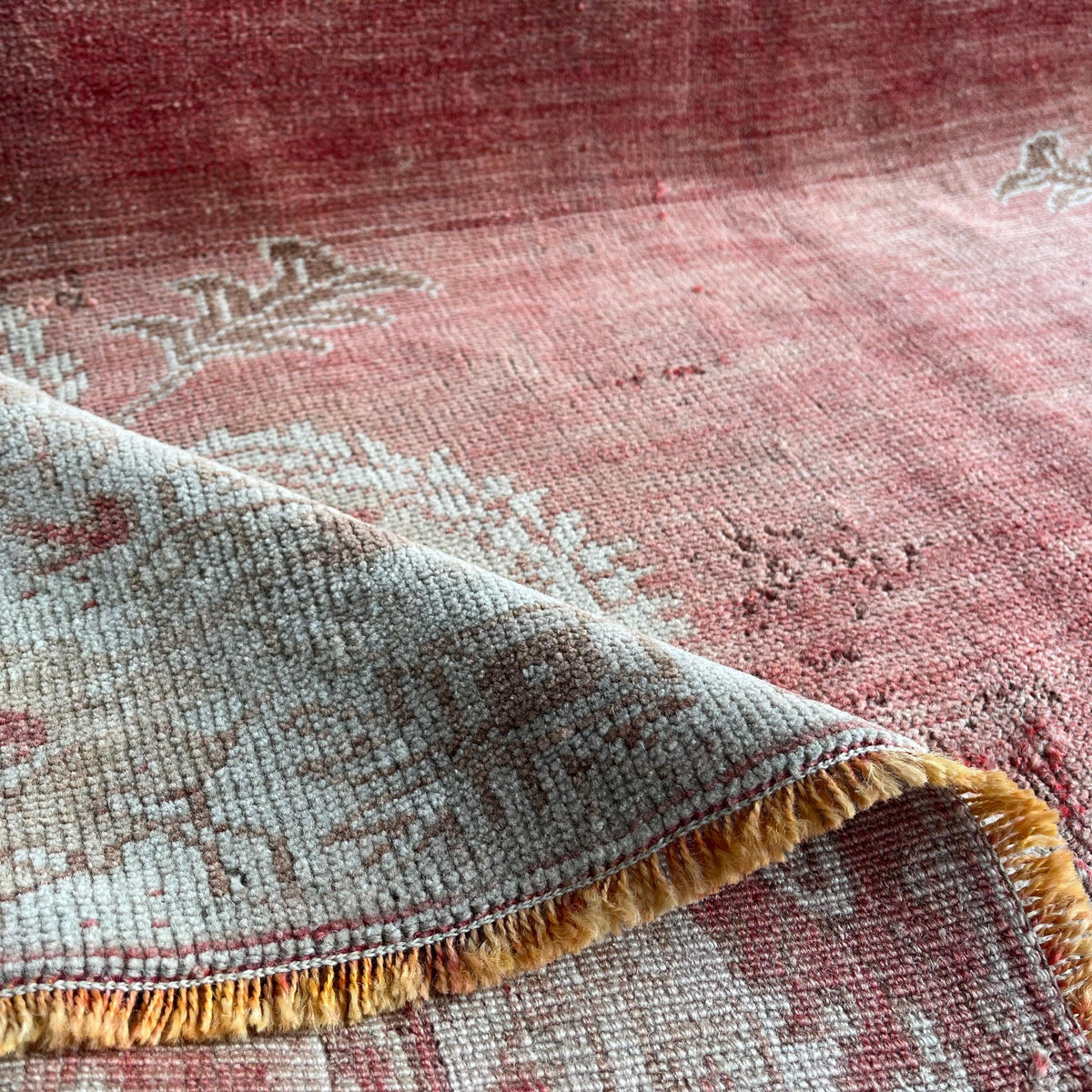 Close-up of the red Turkish oriental wool rug showing medallion details, hand-knotted weave, wool and cotton and low pile.