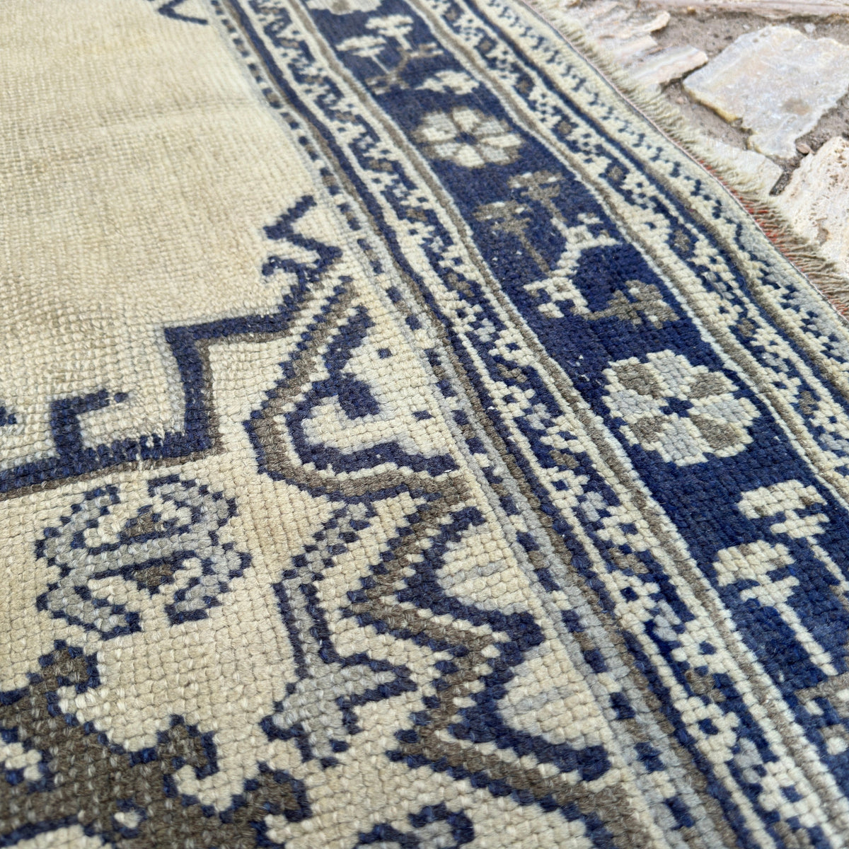 Close-up of the blue Turkish oushak rug showing oushak and medallion details, hand-knotted weave, wool and cotton and low pile.