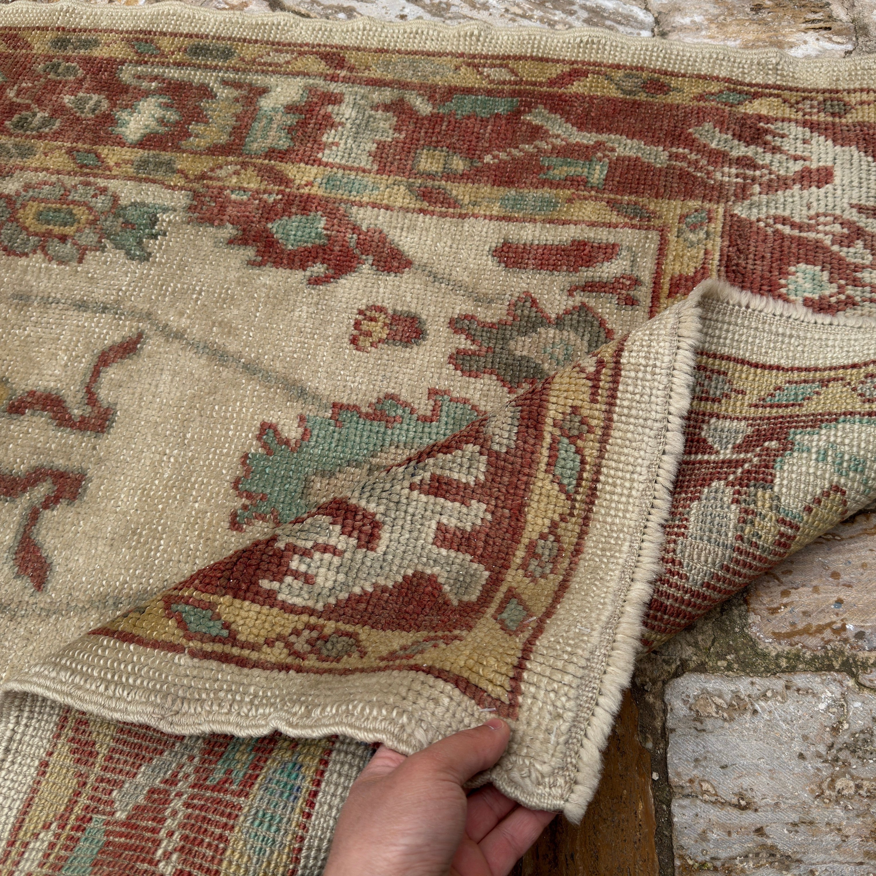 Close-up of the red Turkish oushak runner rug showing oushak details, hand-knotted weave, wool and low pile.