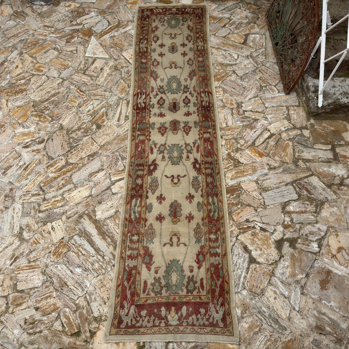 Red 3' x 14' Turkish oushak runner rug in wool, shown on the floor.