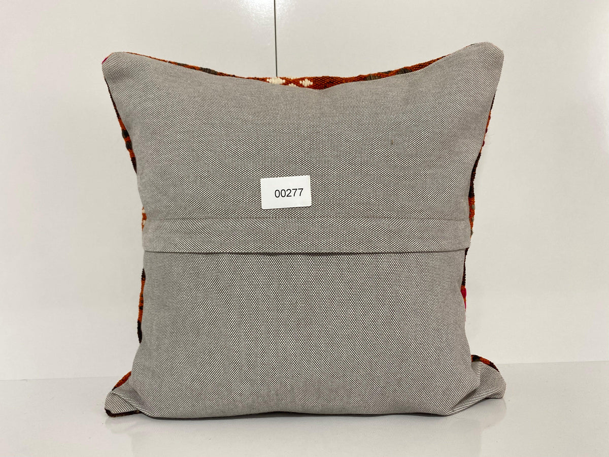 Close-up of the orange Turkish pillow cover showing geometric details, low pile.