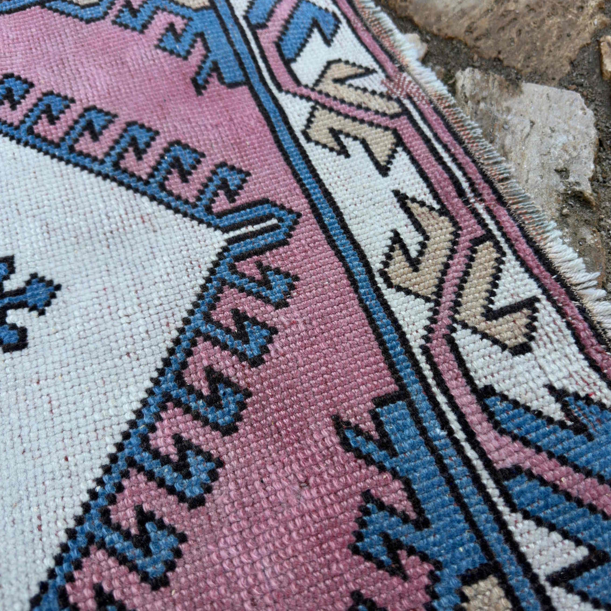 Close-up of the pink Turkish runner rug showing traditional details, hand-knotted weave, wool and cotton and low pile.