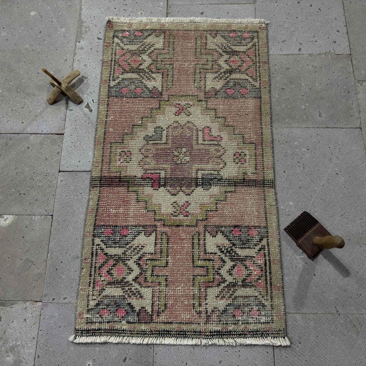 Pink 2' x 3' Turkish small anatolian rug in wool and cotton, shown on the floor.