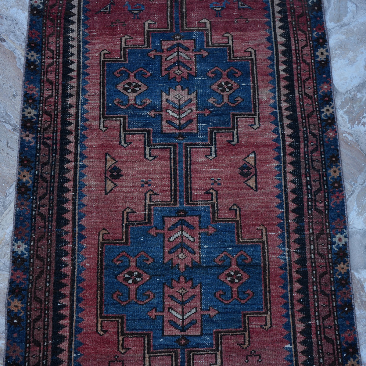 Close-up of the red small persian rug showing traditional details, hand-knotted weave, wool and cotton and low pile.
