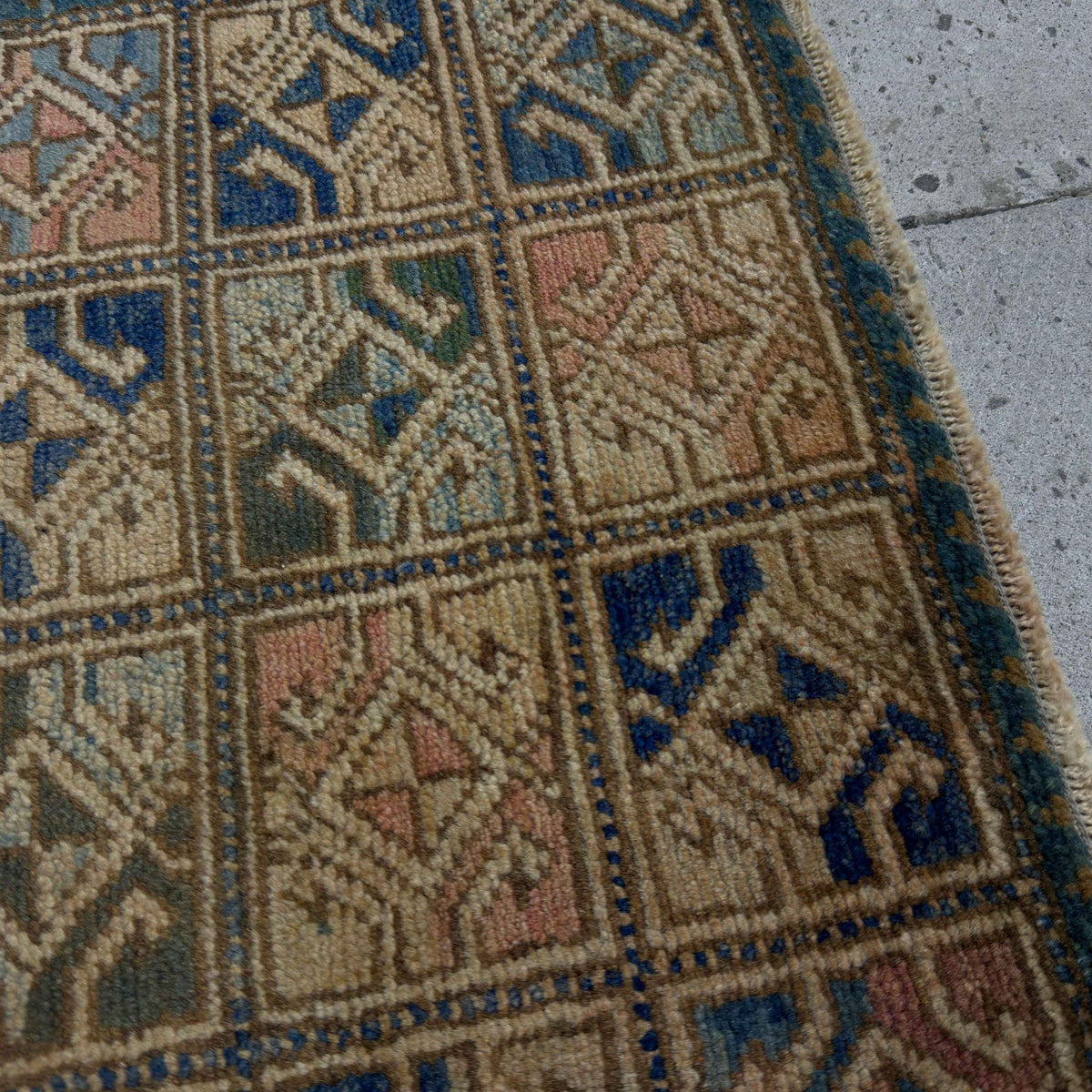 Close-up of the blue Turkish small square rug showing neutral details, hand-knotted weave, wool and cotton and low pile.