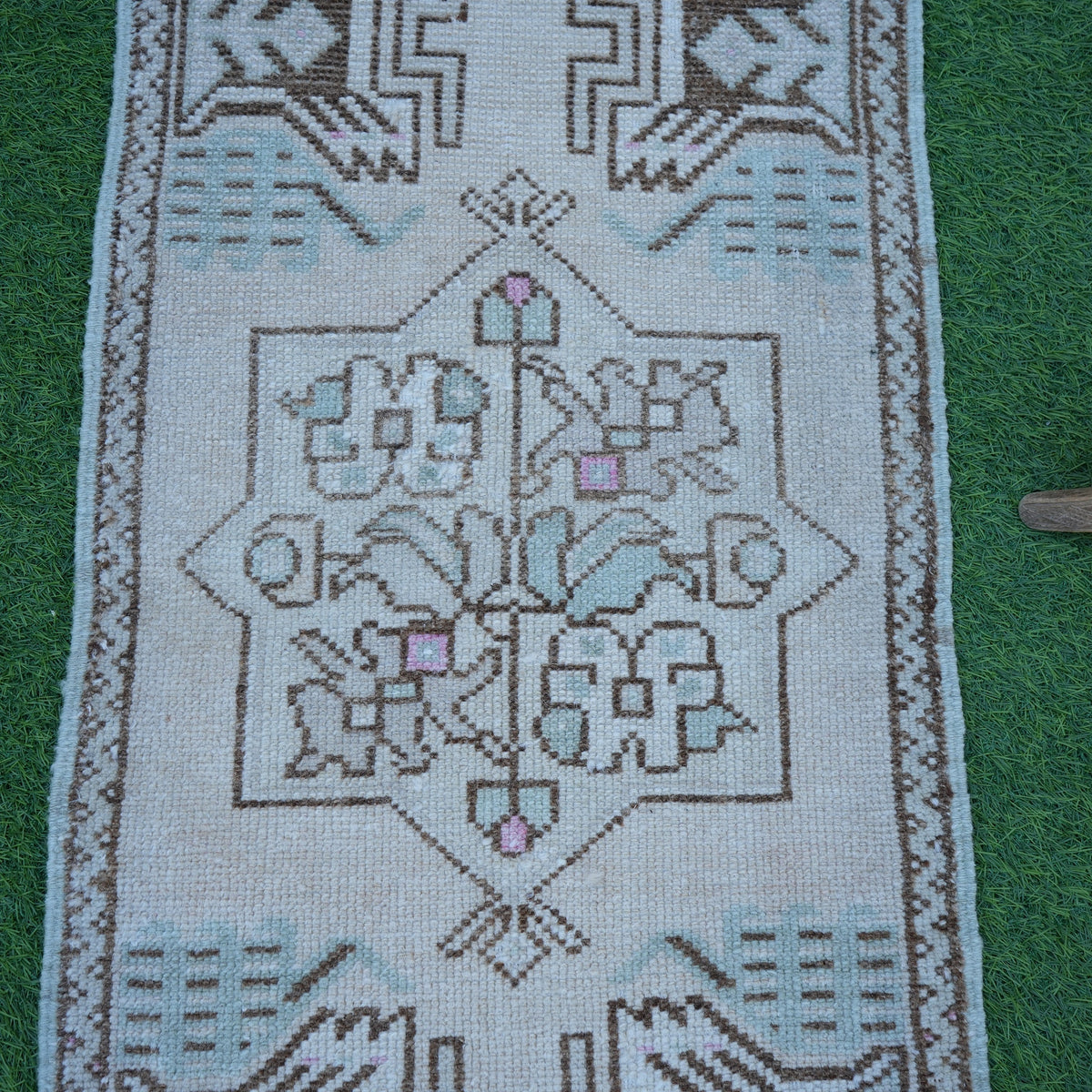Close-up of the beige small turkish rug showing neutral details, hand-knotted weave, wool and cotton and low pile.