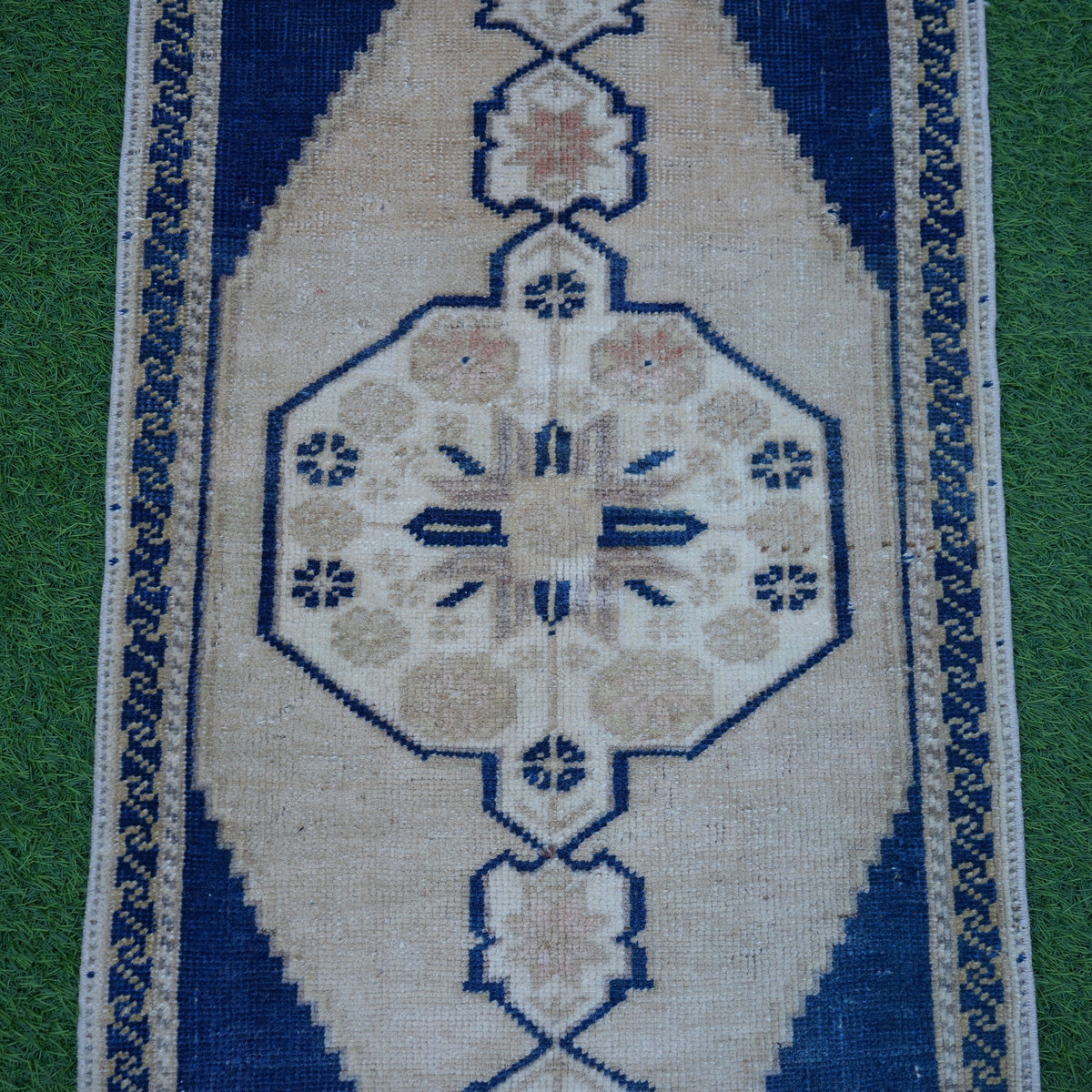 Close-up of the blue small turkish rug showing traditional details, hand-knotted weave, wool and low pile.