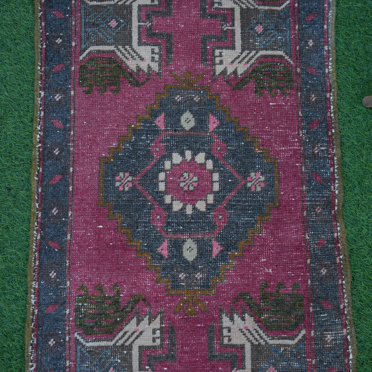 Close-up of the red Turkish small vintage rug showing traditional details, hand-knotted weave, wool and cotton and low pile.