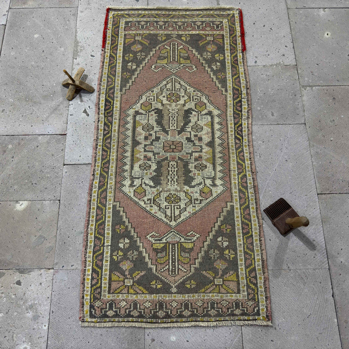 Pink 2' x 4' Turkish small vintage rug in wool and cotton, shown on the floor.