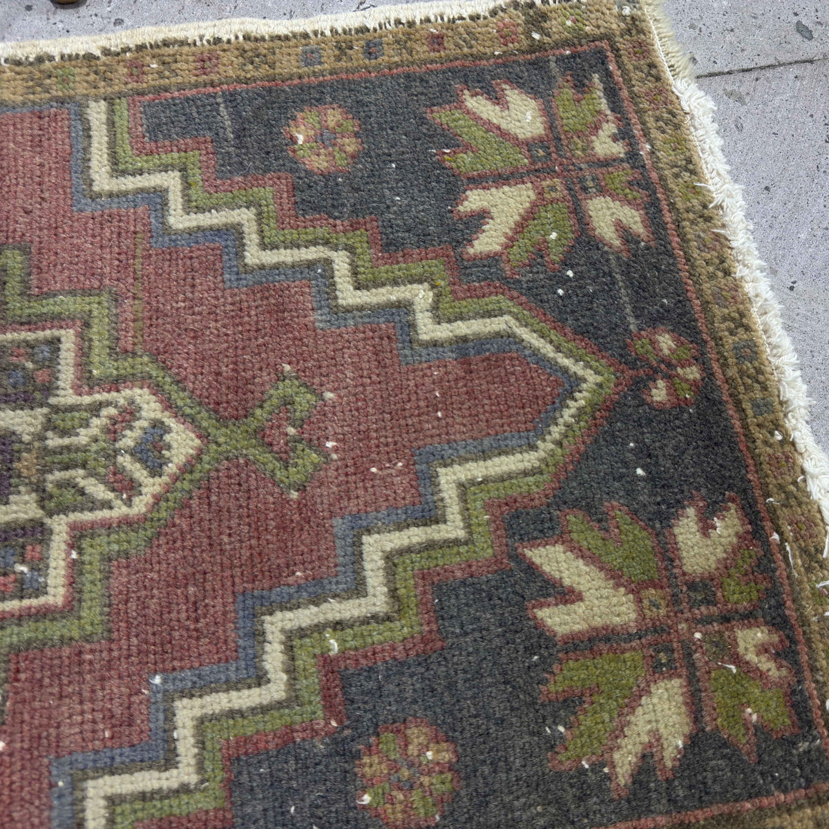 Close-up of the red Turkish small vintage rug showing traditional details, hand-knotted weave, wool and cotton and low pile.