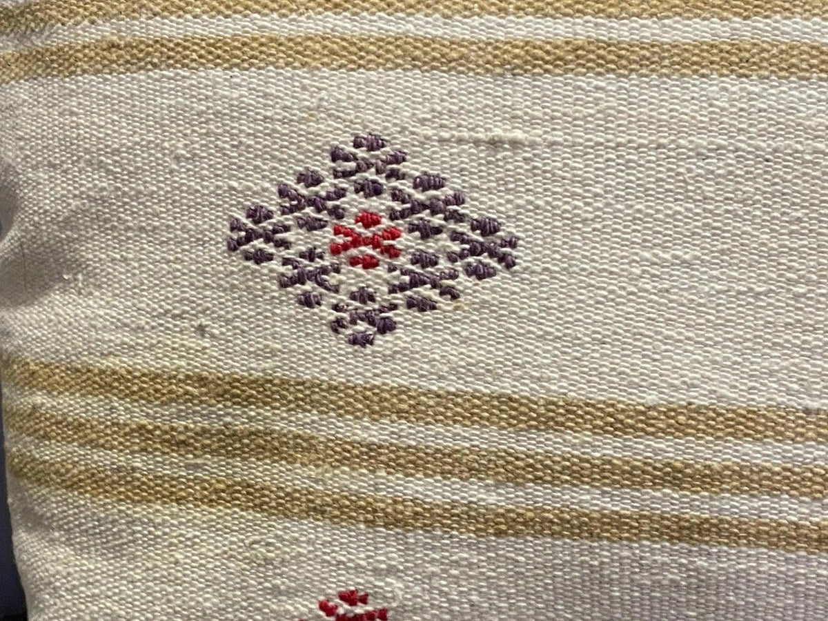 Close-up of the beige Turkish throw pillow showing striped details, low pile.