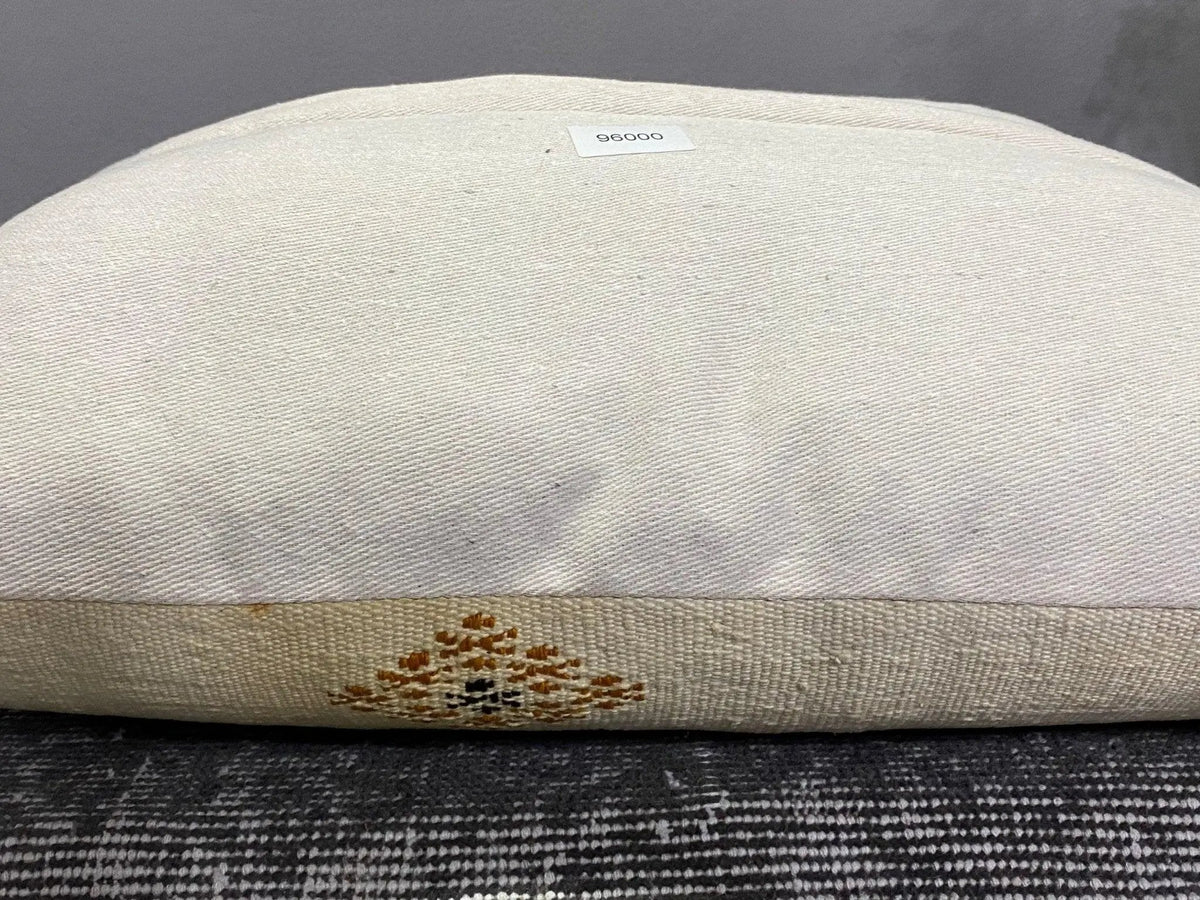 Beige Turkish throw pillow, shown on the floor.