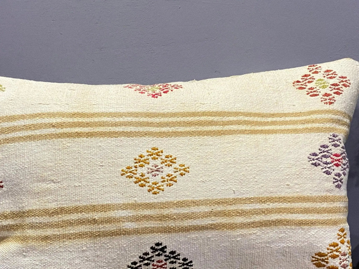Close-up of the beige Turkish throw pillow showing striped details, low pile.