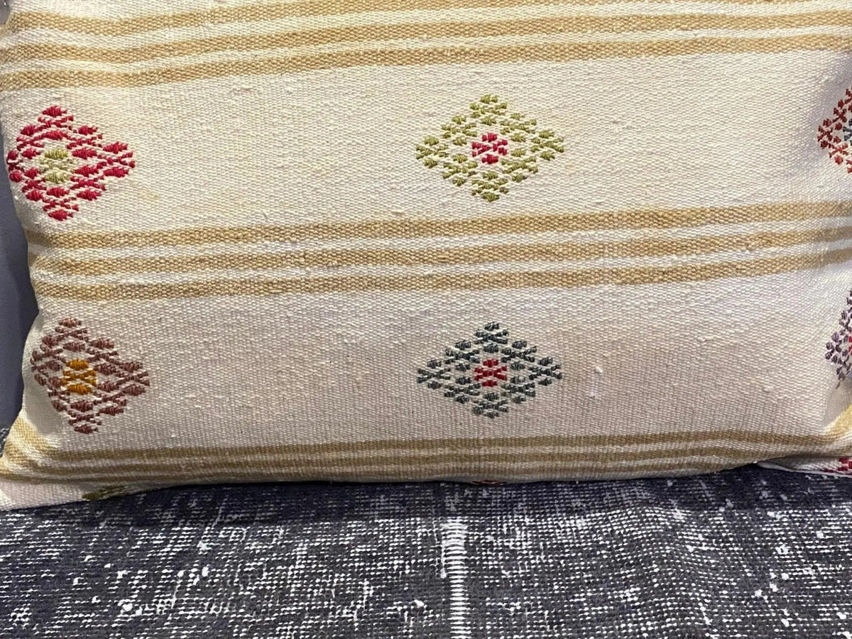 Close-up of the beige Turkish throw pillow showing striped details, low pile.