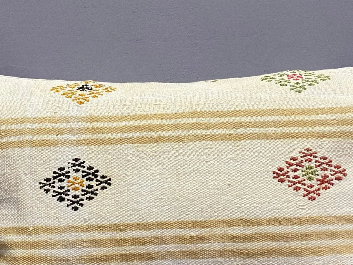 Close-up of the colorful Turkish throw pillow showing striped details, low pile.