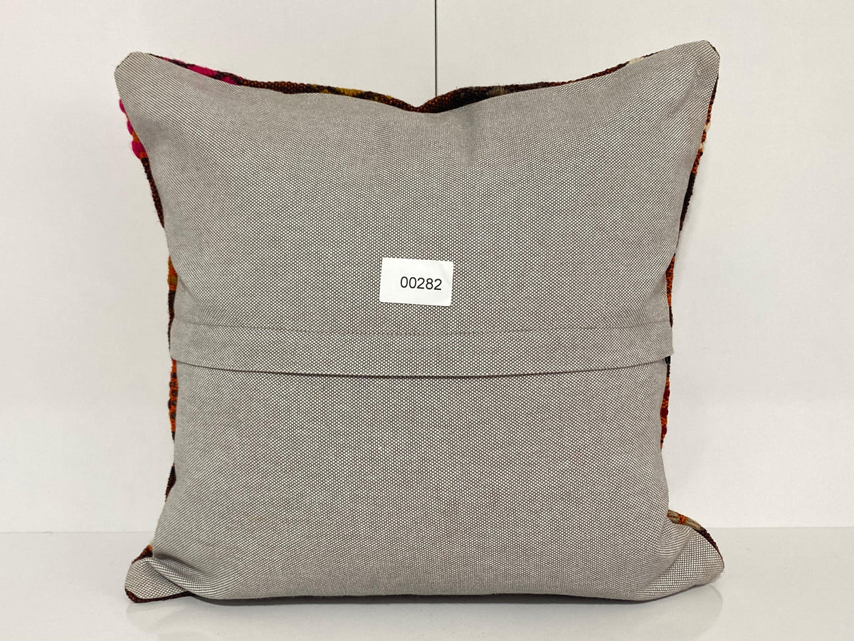 Close-up of the orange Turkish throw pillow showing geometric details, low pile.