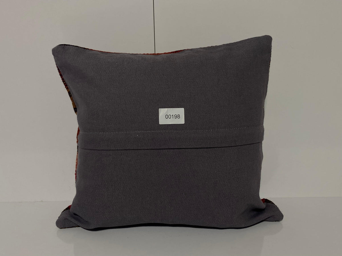 Close-up of the red Turkish throw pillow showing striped details, low pile.