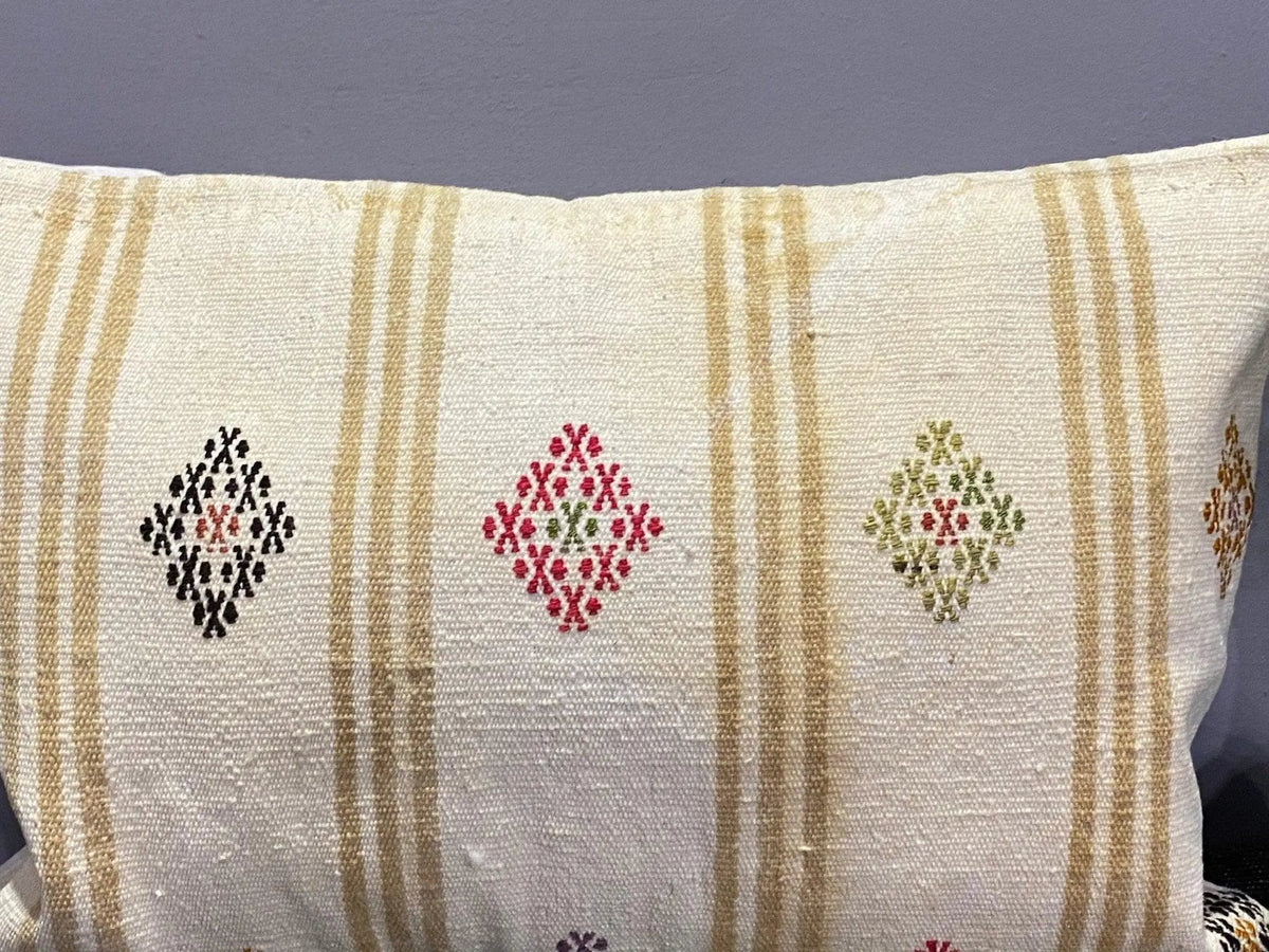 Close-up of the white Turkish throw pillow showing striped details, low pile.