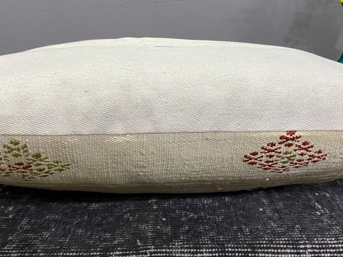 White Turkish throw pillow, shown on the floor.