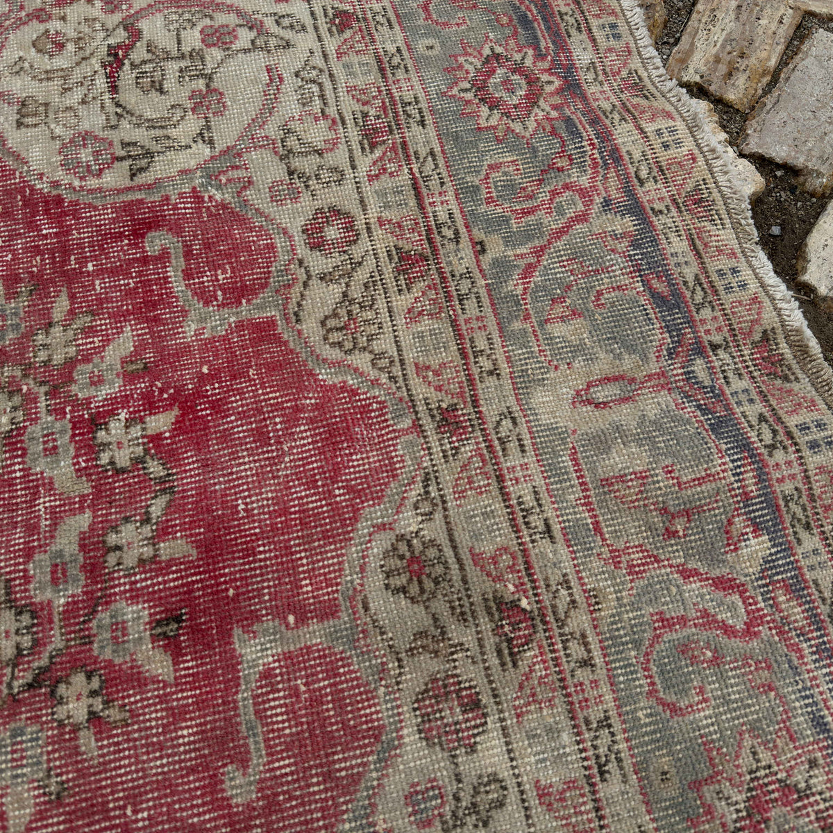 Close-up of the red Turkish traditional anatolian rug showing traditional details, hand-knotted weave, wool and cotton and low pile.
