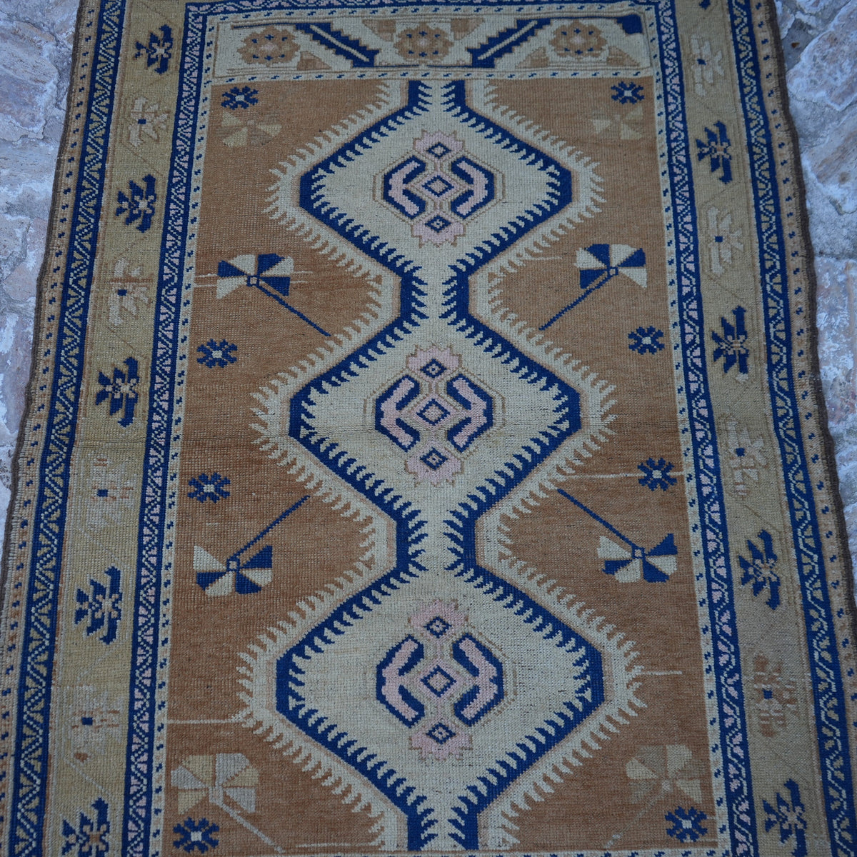 Close-up of the beige turkish area rug showing traditional details, hand-knotted weave, wool and low pile.
