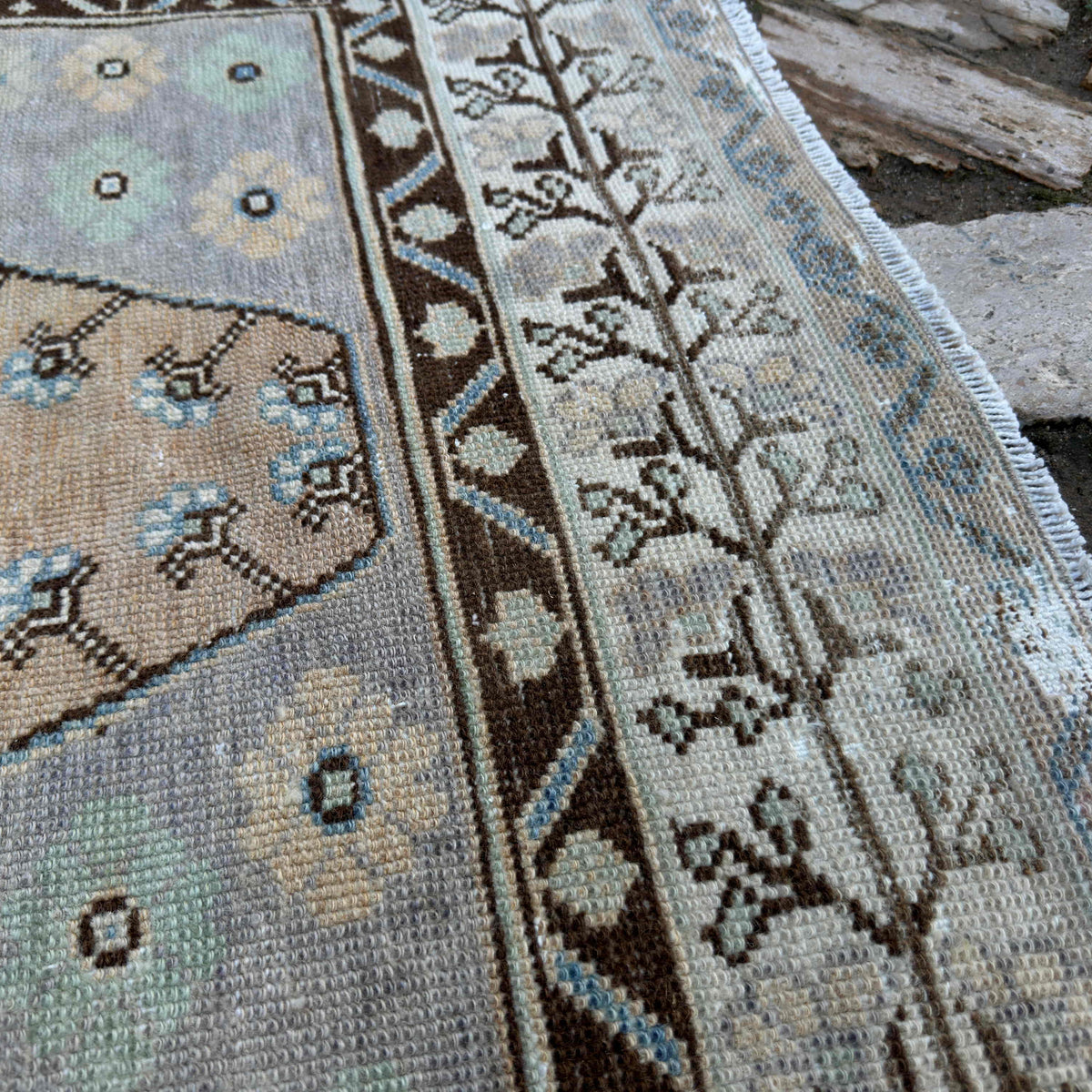 Close-up of the pale orange turkish area rug showing traditional details, hand-knotted weave, wool and cotton and low pile.