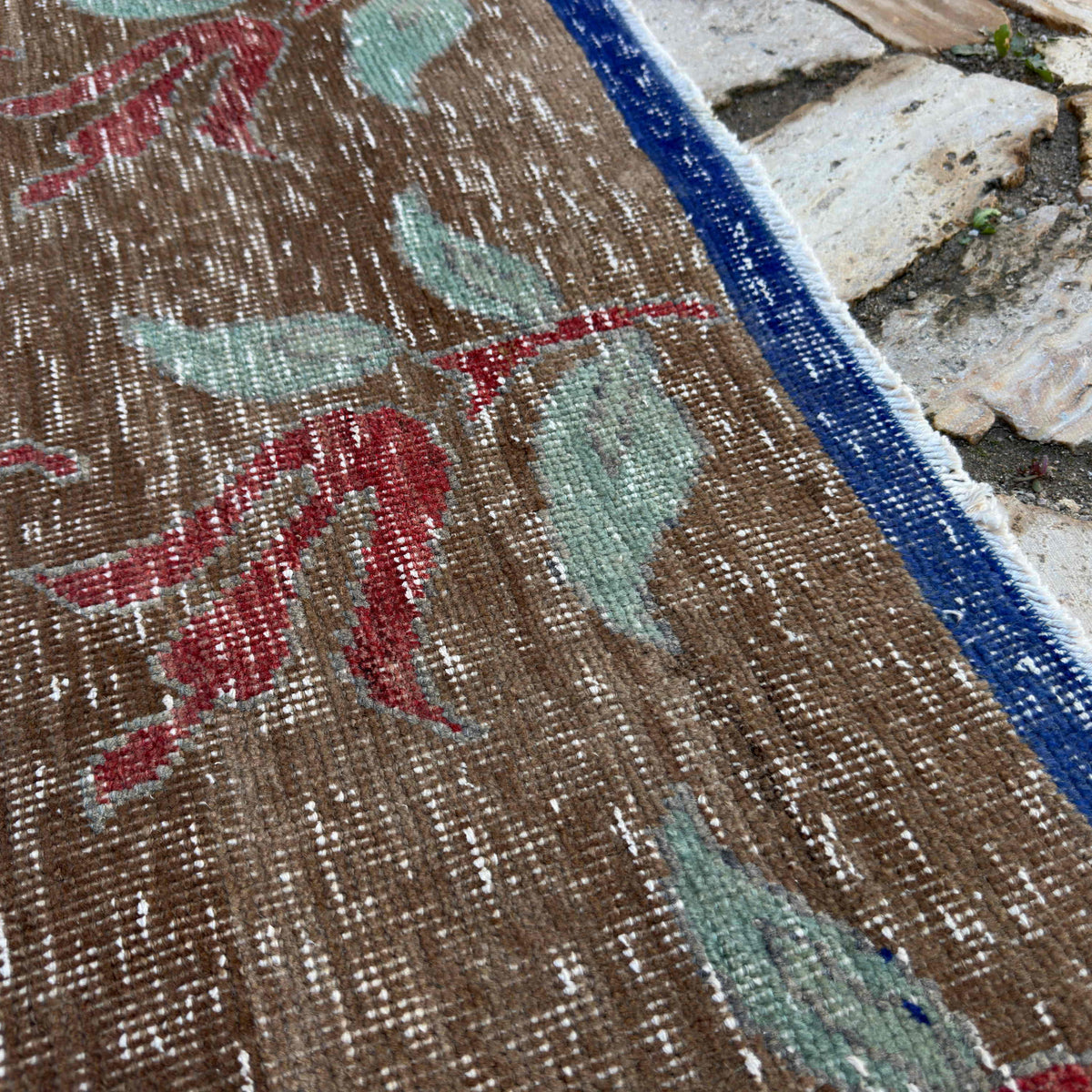 Close-up of the pale brown turkish floral rug showing floral details, hand-knotted weave, wool and cotton and low pile.