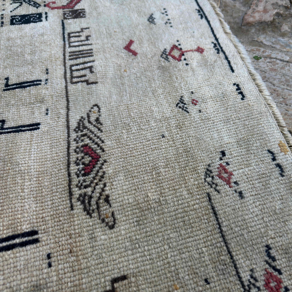 Close-up of the red turkish geometric rug showing traditional details, hand-knotted weave, wool and cotton and low pile.