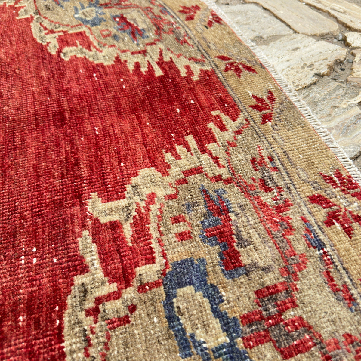 Close-up of the red turkish medallion rug showing medallion details, hand-knotted weave, wool and cotton and low pile.