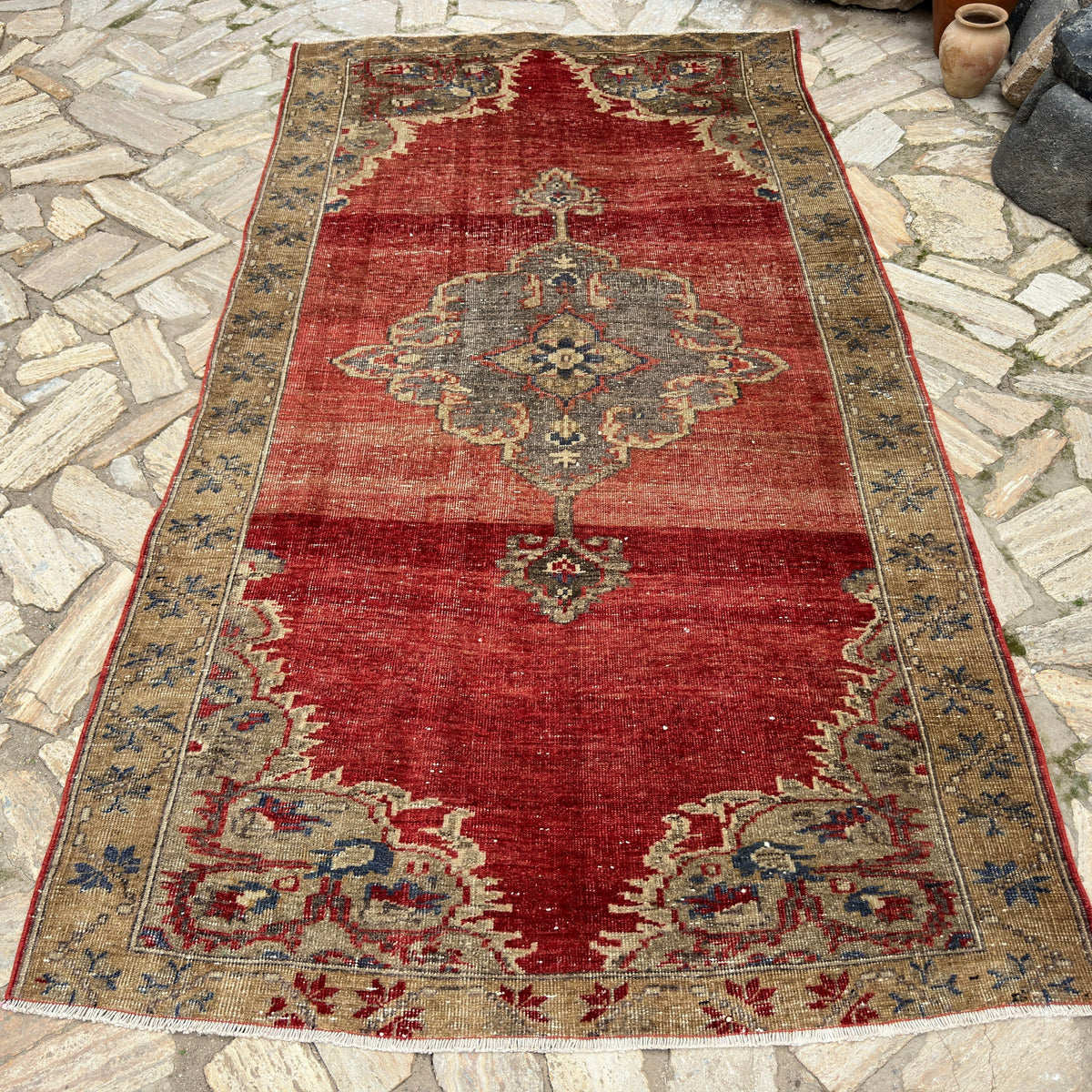 Red 5' x 9' turkish medallion rug in wool and cotton, shown on the floor.