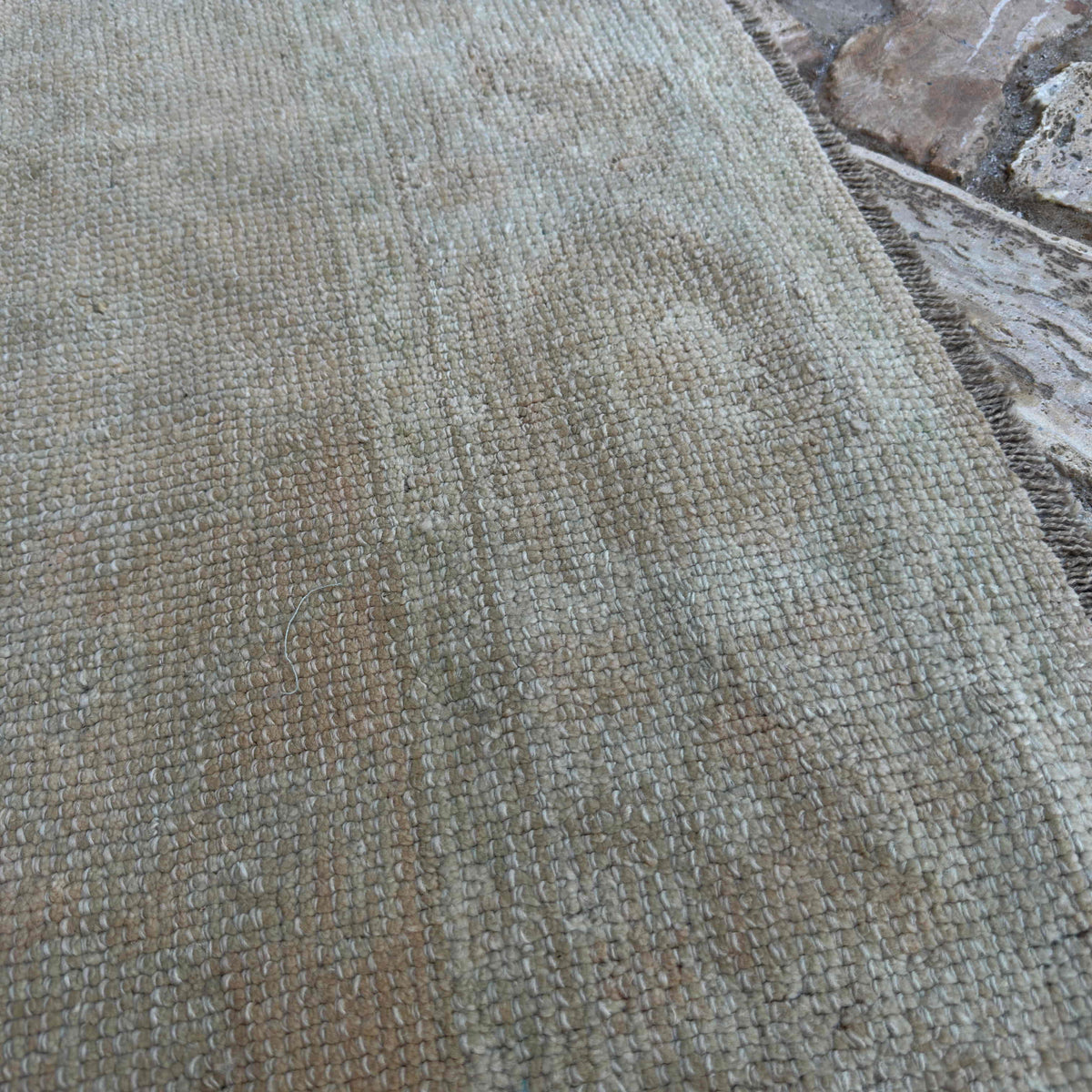 Close-up of the beige turkish oushak rug showing neutral details, hand-knotted weave, wool and cotton and low pile.