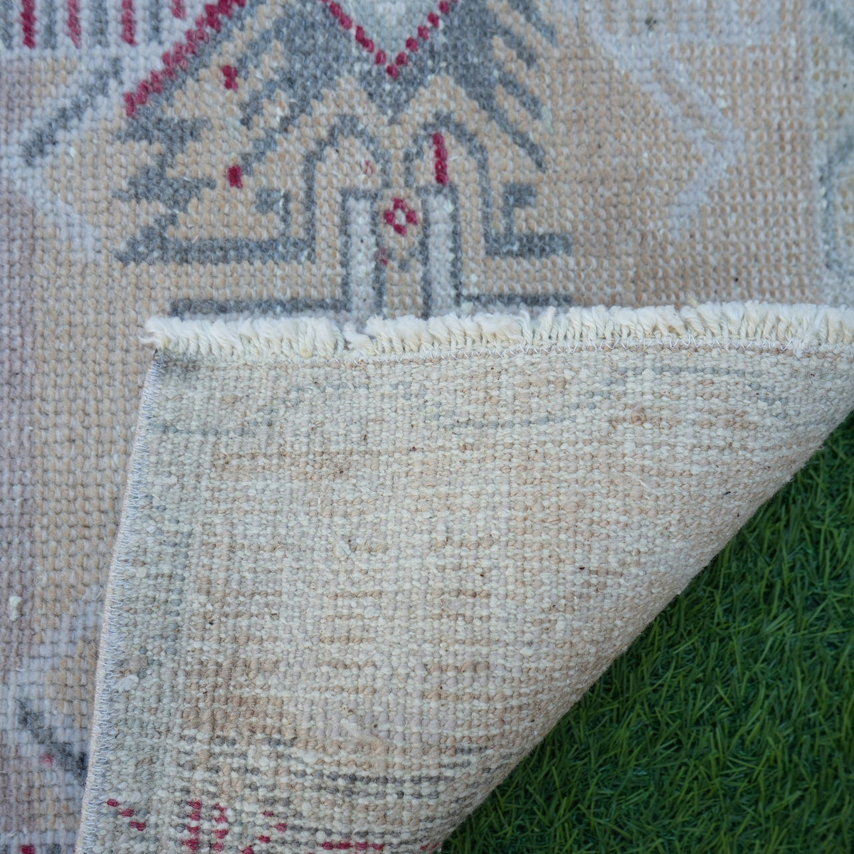 1970s pink turkish rug with neutral design, hand-knotted weave and low pile.