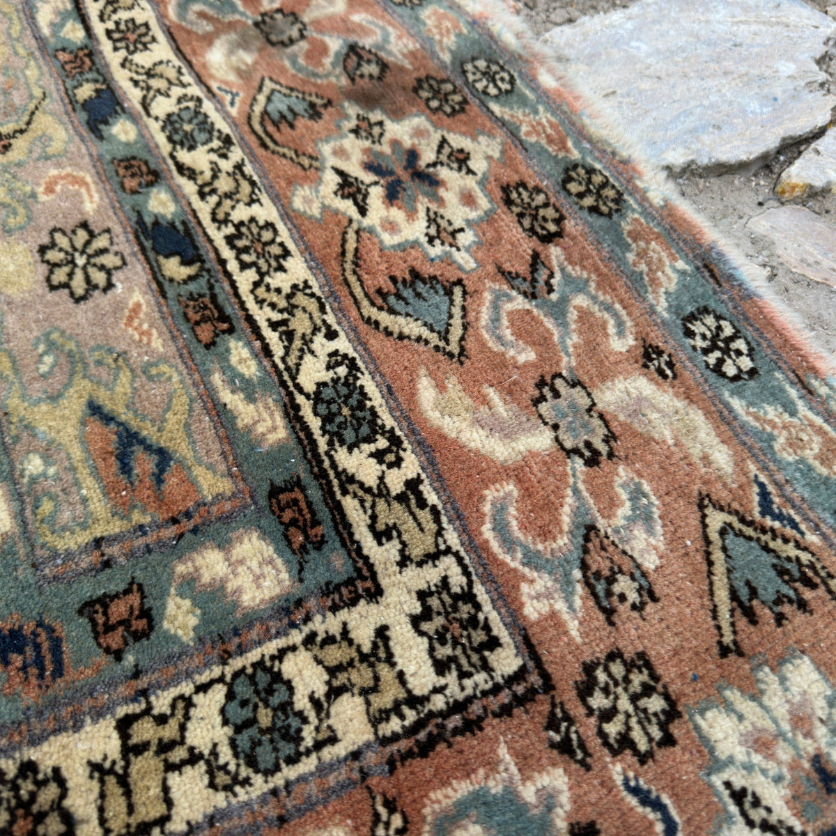 Close-up of the beige turkish rug showing geometric details, hand-knotted weave, wool and cotton and low pile.